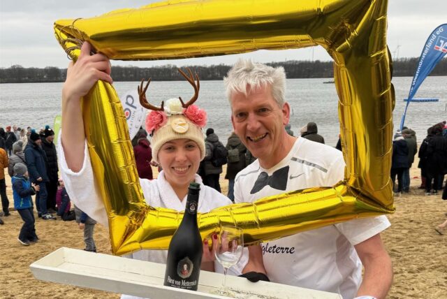 Olaf Krumnack und Tochter Amelie blicken durch einen aufblasbaren goldenen Bilderrahmen.