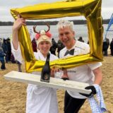 Olaf Krumnack und Tochter Amelie blicken durch einen aufblasbaren goldenen Bilderrahmen.
