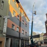 Im Personenkorb stehen zwei Dachdecker, die sich um das Loch im Dachstuhl in Datteln kümmern.