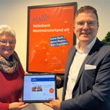 Anne Feldmann mit Henning Henke vor einem Volksbank-Plakat