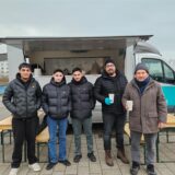 Fünf Männer stehen vor einem Suppenwagen