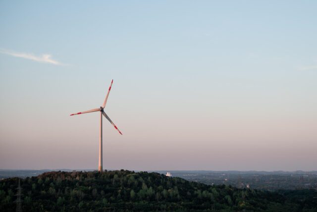 Ein Windrad steht bei Sonnenaufgang nahe der Halde Hoheward in Herten.