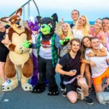 Auf dem Plateau der Halde Hoheward in Herten-Süd hat sich eine Besuchergruppe des Haldenglühens zum Gruppenfoto aufgestellt. Drei Personen sind in einem Kostüm.