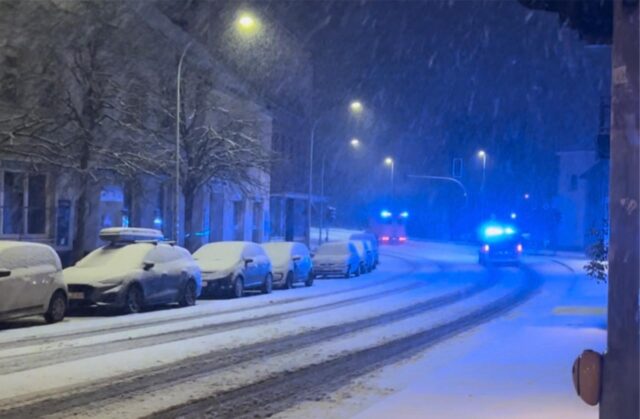 Schneebedeckte Straße und Autos
