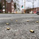 Leere Patronenhülse in Messingfarbe auf dem Asphalt