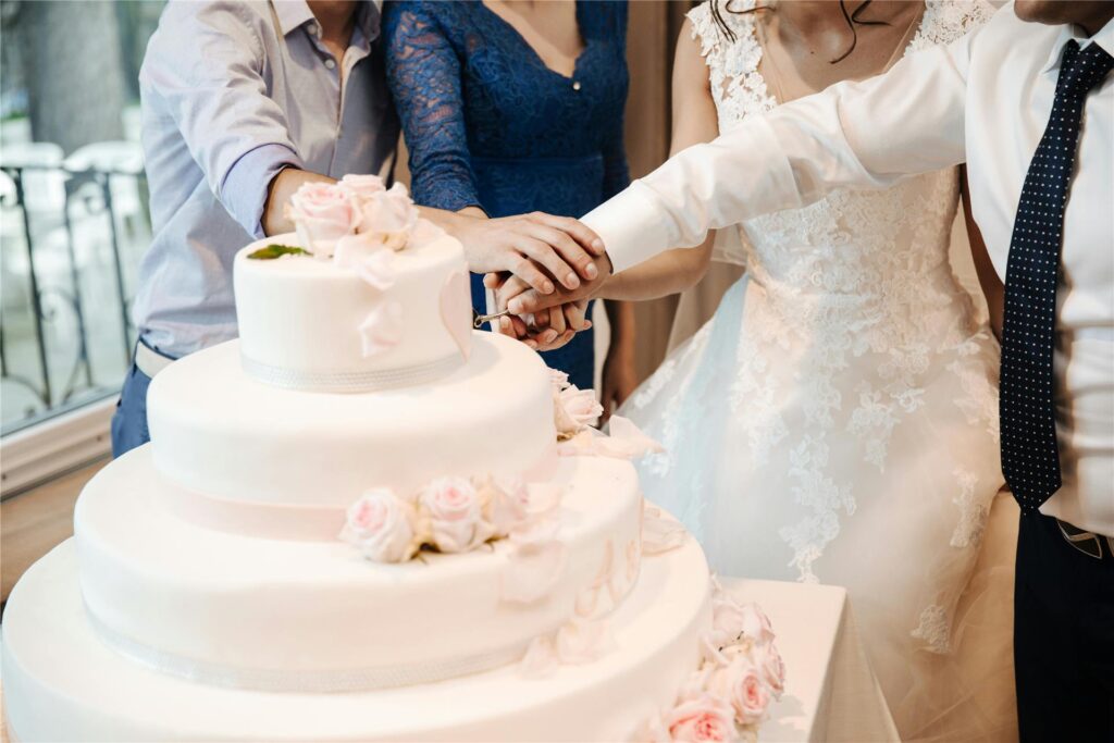 Ein Brautpaar schneidet die Hochzeitstorte an. Ein Brautpaar schneidet die Hochzeitstorte an.