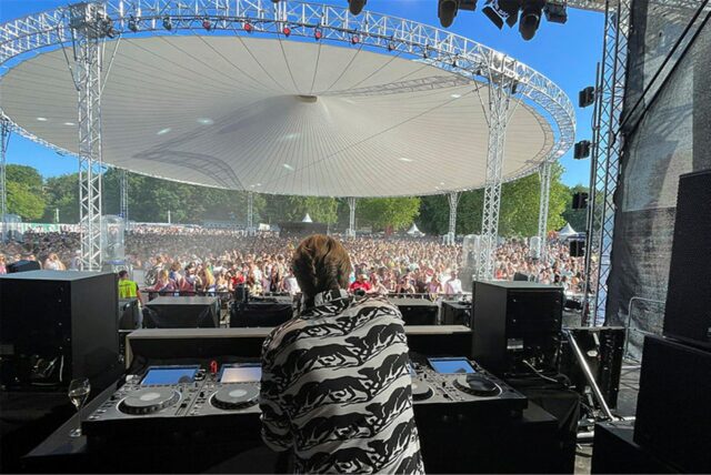 Phil Fuldner steht hinter dem DJ-Pult auf der Bühne beim Sunset Beach Festival 2024.