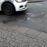 Ein Auto fährt über ein Schlagloch in Datteln.