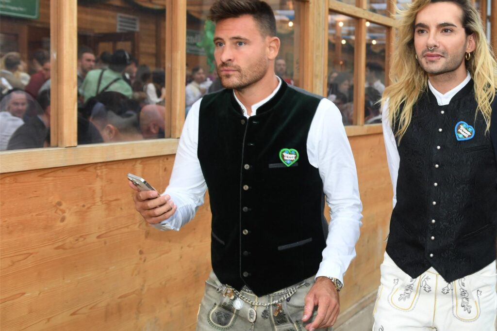Model Marc Eggers, Kandidat von Let's Dance 2025, und Tokio-Hotel-Sänger Bill Kaulitz verlassen das Schützenzelt beim Oktoberfest in München.
