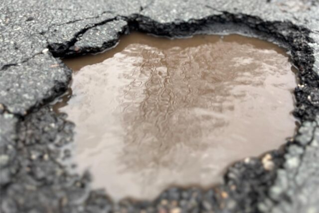 Ein Schlagloch auf der Straße Im Löhken in Waltrop, in dem Regenwasser steht.