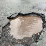 Ein Schlagloch auf der Straße Im Löhken in Waltrop, in dem Regenwasser steht.