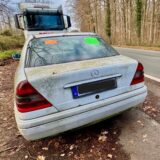 Immer wieder muss die Stadt Dortmund Schrottautos wie diesen weißen Mercedes aus dem öffentlichen Straßenraum entfernen lassen. Sprecher Christian Stein erläutert das Vorgehen des Ordnungsamts.