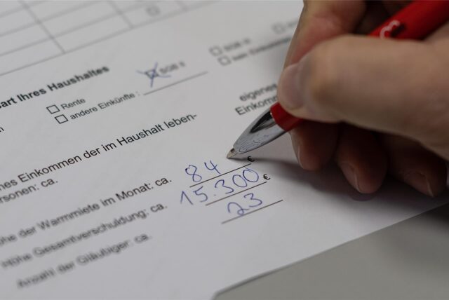 Ein Mitarbeiter der Schuldnerberatung von der AWO füllt ein Formular zur Datenerfassung aus.