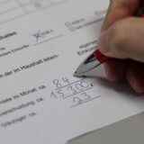 Ein Mitarbeiter der Schuldnerberatung von der AWO füllt ein Formular zur Datenerfassung aus.