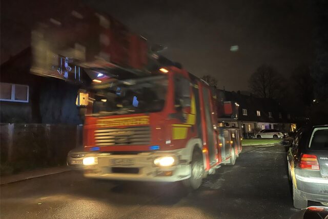 Ein Feuerwehrfahrzeug fährt eine Straße entlang.