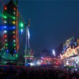 Menschen laufen zwischen Fahrgeschäften über die Allerheiligenkirmes in Soest, eine der größten Kirmessen in NRW.