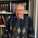 Volker Ruckh steht in seinem Arbeitszimmer in Datteln vor einem Schrank mit vielen Steckbüchern voller Briefmarken.