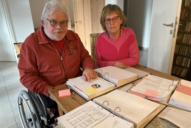 Ingo Remberg und seiner Frau Silke Nissen-Remberg vor mehreren dicken Aktenordnern.