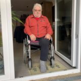Ingo Remberg sitzt im Rollstuhl im Zugangsbereich zur Terrasse.
