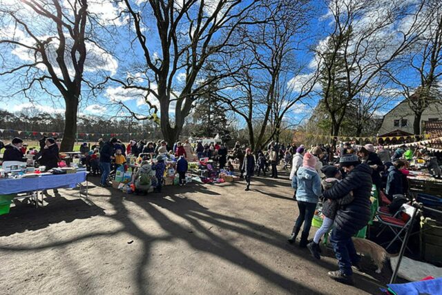 Stände auf dem Trödelmarkt und Menschen, die sich die Ware anschauen.