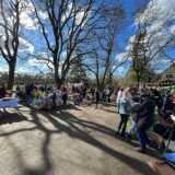 Stände auf dem Trödelmarkt und Menschen, die sich die Ware anschauen.