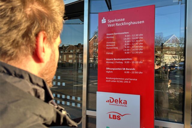 Eine Person steht vor dem Eingang zur Sparkasse in Dorsten.