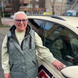 Brigitte Meer steht neben einem Taxi.