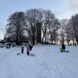 Kinder mit Schlitten im Schnee.