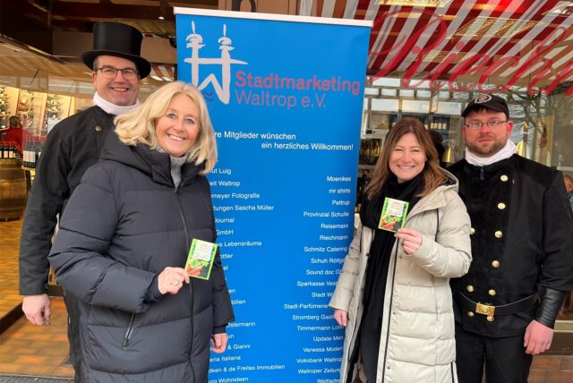 Uwe Chaberny, Nicole Moenikes, Ines Schulte und Matthias Späth bei der Schornsteinfeger-Aktion in der Waltroper Innenstadt vor einem Roll-up des Stadtmarketings.