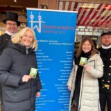 Uwe Chaberny, Nicole Moenikes, Ines Schulte und Matthias Späth bei der Schornsteinfeger-Aktion in der Waltroper Innenstadt vor einem Roll-up des Stadtmarketings.