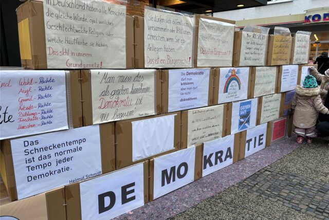 Auf der Karton-Wand der Omas gegen Rechts in der Dattelner Fußgängerzone stehen Zitate und Informationen rund um die Themen Demokratie und Bürgerrechte.