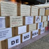 Auf der Karton-Wand der Omas gegen Rechts in der Dattelner Fußgängerzone stehen Zitate und Informationen rund um die Themen Demokratie und Bürgerrechte.