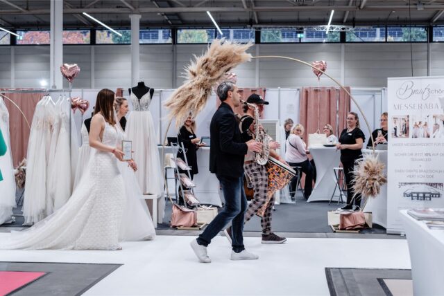 Musiker und Frauen in Brautkleidern auf der Hochzeitsmesse „Hochzeitstage“ in Dortmund.