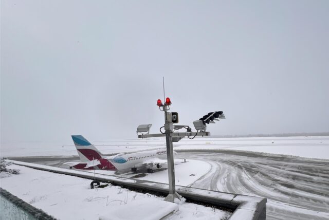 Ein Flugzeug steht auf dem mit Schnee bedeckten Rollfeld am Flughafen Dortmund.