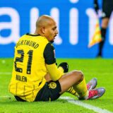Donyell Malen sitzt auf dem Rasen.