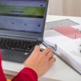 Eine Frau füllt eine Steuererklärung am Laptop aus.