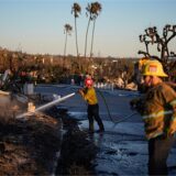 Apple Valley Fire District Captain Manuel Lafarga, Mitte, und Feuerwehrmann James Lyons spritzen heiße Stellen nach dem Palisades Fire im Stadtteil Pacific Palisades von Los Angeles ab.