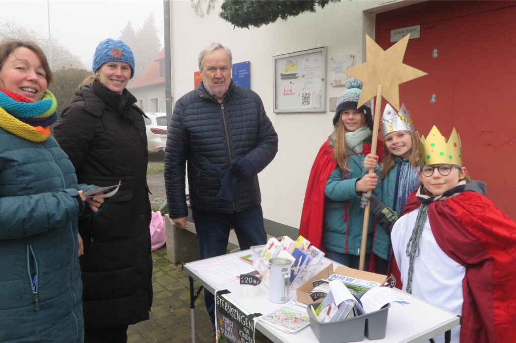 Erwachsene am Stand der Sternsinger