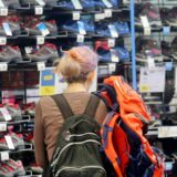 Links begutachtet eine Frau Wanderschuhe in einer Decathlon-Filiale, rechts das Einkaufszentrum Palais Vest in Recklinghausen.