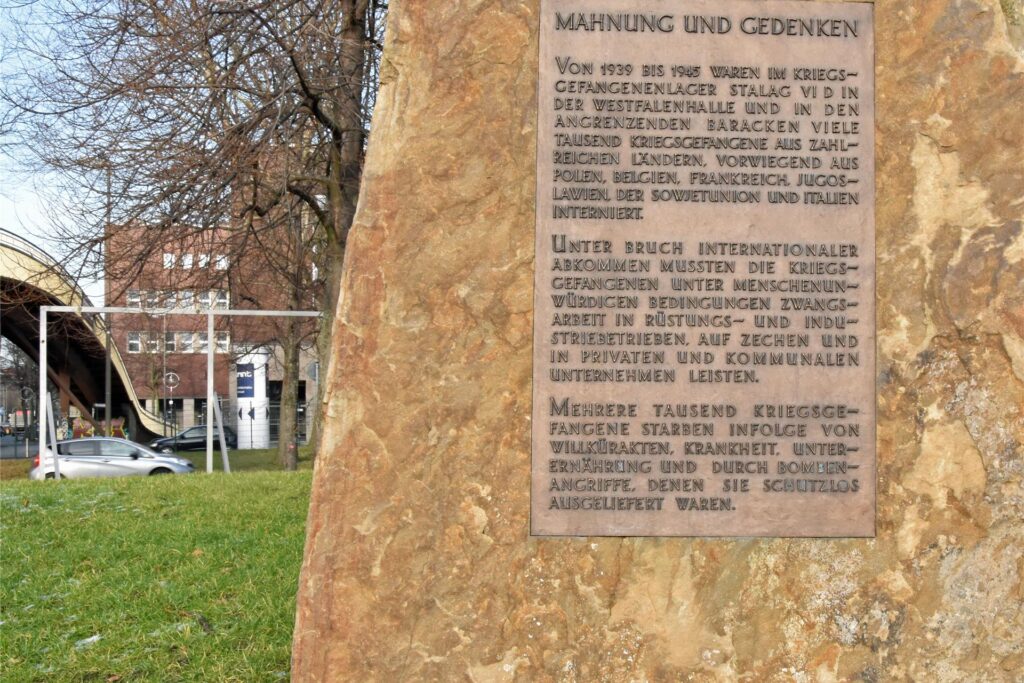 Dieser Mahn- und Gedenkstein erinnert an das Stalag VI D und seine Gefangenen. Das Mahnmal steht an der Brücke in Richtung Lindemannstraße. Dieser Mahn- und Gedenkstein erinnert an das Stalag VI D und seine Gefangenen. Das Mahnmal steht an der Brücke in Richtung Lindemannstraße.