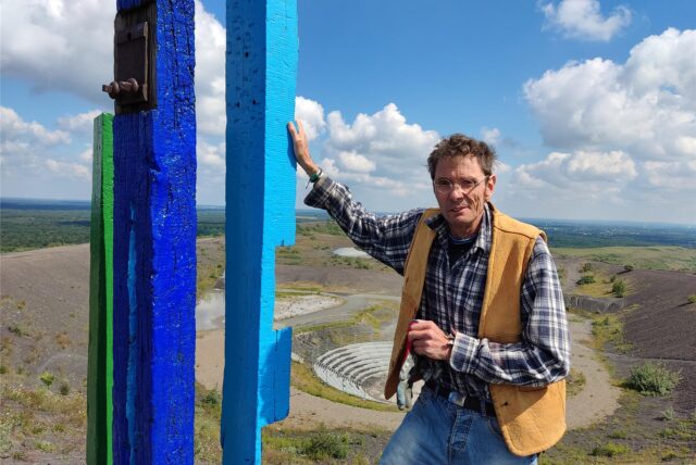 Guido Hofmann steht an einer der bunten Stelen auf der Halde Haniel bei Bottrop.