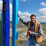 Guido Hofmann steht an einer der bunten Stelen auf der Halde Haniel bei Bottrop.