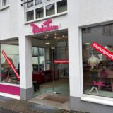 Außenansicht von TinkaTom, einem Geschäft für Kinderkleidung an der Straße Caspersgässchen in der Innenstadt von Recklinghausen. Auf zwei Schaufenstern sowie der gläsernen Eingangstür kleben rote Aufkleber, auf denen in weißer Schrift Räumungsverkauf steht.