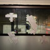 Einschusslöcher im Schaufenster eines Tattoostudios in Dortmund sind mit Klebeband abgeklebt.