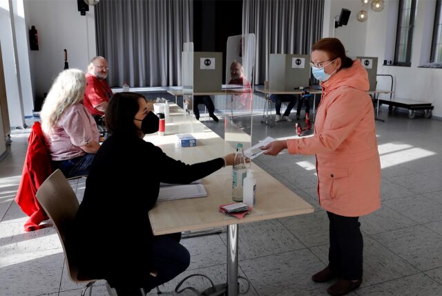 Eine Frau gibt ihren Stimmzettel im Wahllokal ab.