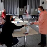 Eine Frau gibt ihren Stimmzettel im Wahllokal ab.