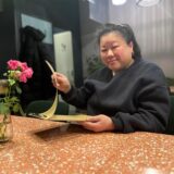 Restaurant-Inhaberin Hao Dang blättert im Nosh no.2 im Dortmunder Kreuzviertel in einer Speisekarte.