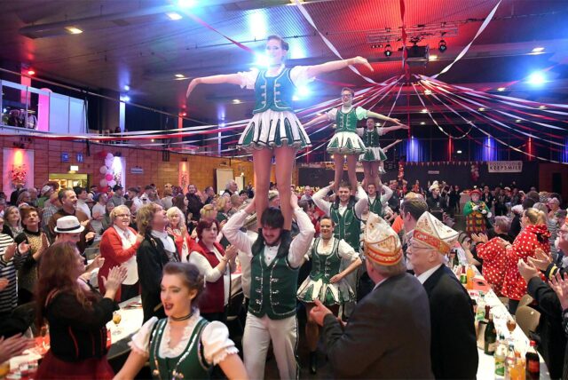 Eine Karnevalssitzung im Europasaal. Die Tanzgarde läuft den Gang zur Bühne entlang.