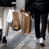 Menschen gehen mit Einkaufstüten am verkaufsoffenen Sonntag durch die Innenstadt.