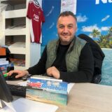Erhan Nane lächelt an seinem Schreibtisch.